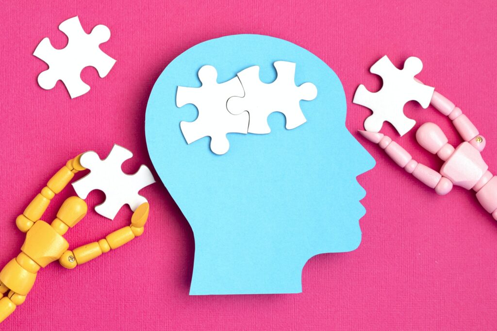 Papercut head with jigsaw puzzle pieces inside. Mental health problems, psychology, memory, logic