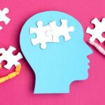 Papercut head with jigsaw puzzle pieces inside. Mental health problems, psychology, memory, logic