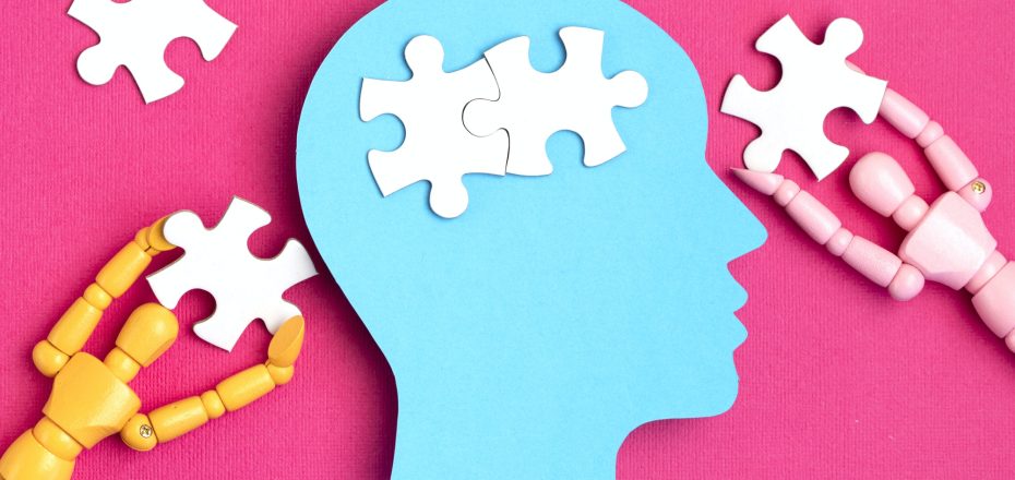 Papercut head with jigsaw puzzle pieces inside. Mental health problems, psychology, memory, logic